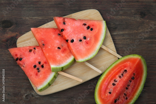 Cut delicious ripe watermelon on wooden table, flat lay