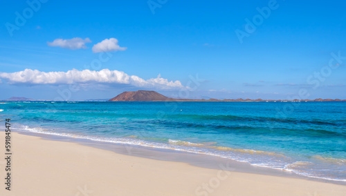 View on Corralejo beach and Lobos island, blue water and golden sand and the Canary Island Fuerteventura, Spain.