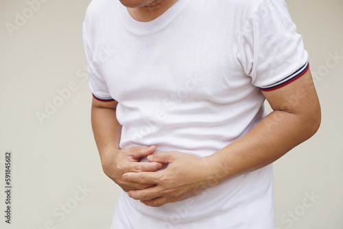Man has a stomachache, uses his hands to touch abdomen. Concept, health problems. Bowel or stomach diseases. Feeling hurt and suffer from physical illness in daily life. 