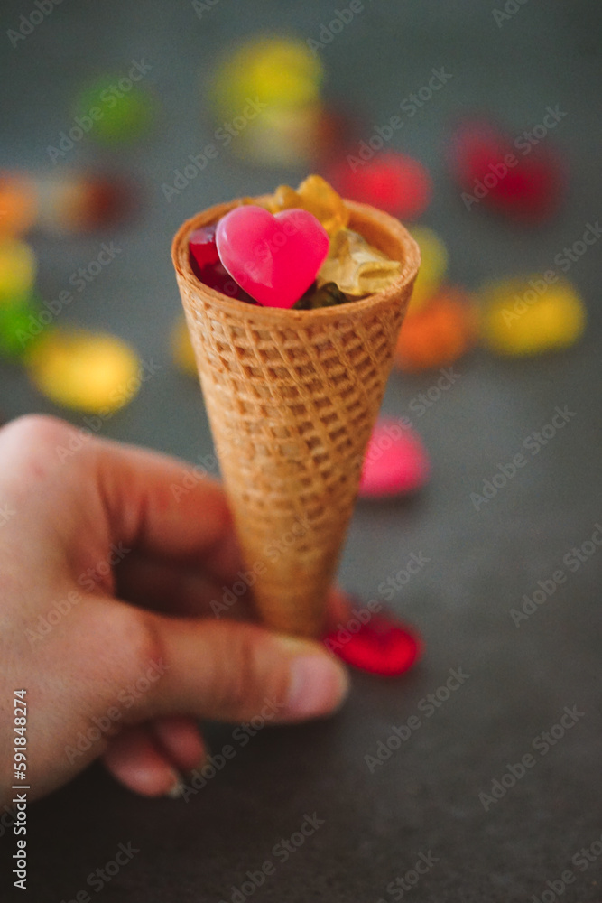 Vertical closeup shot of an ice cream cone filled with gummy bears and jellies Vertical closeup shot of an ice cream cone filled with gummy bears and jellies