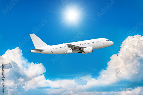 White passenger airplane in the air above picturesque clouds