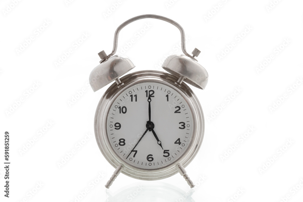small metal alarm clock on a white background, time is 5 o'clock small metal alarm clock on a white background, time is 5 o'clock