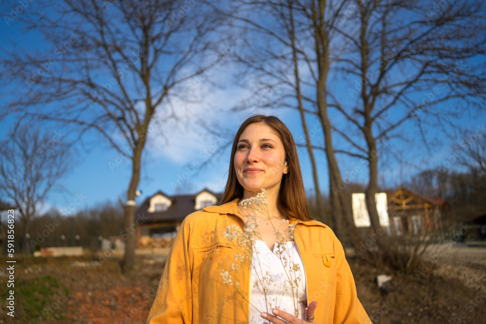 Portrait image of a happy woman standing in park, weekend acitivities.
Portrait image of a happy woman standing in park, weekend acitivities.