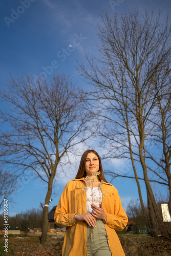 Portrait image of a happy woman standing in park, weekend acitivities.
 photo