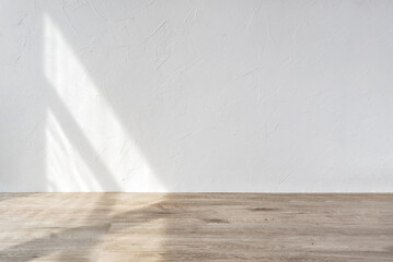 Aesthetic geometric sunlight shadows on white textured wall and beige wooden floor, empty template for home room interior product, background for branding design showcase, copy space