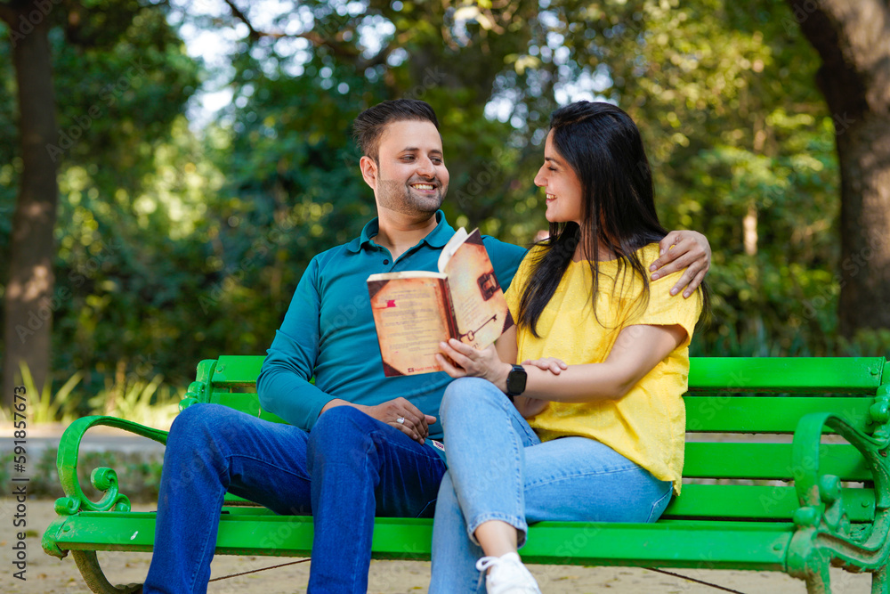 Young indian man and woman reading book at park. Young indian man and woman reading book at park.