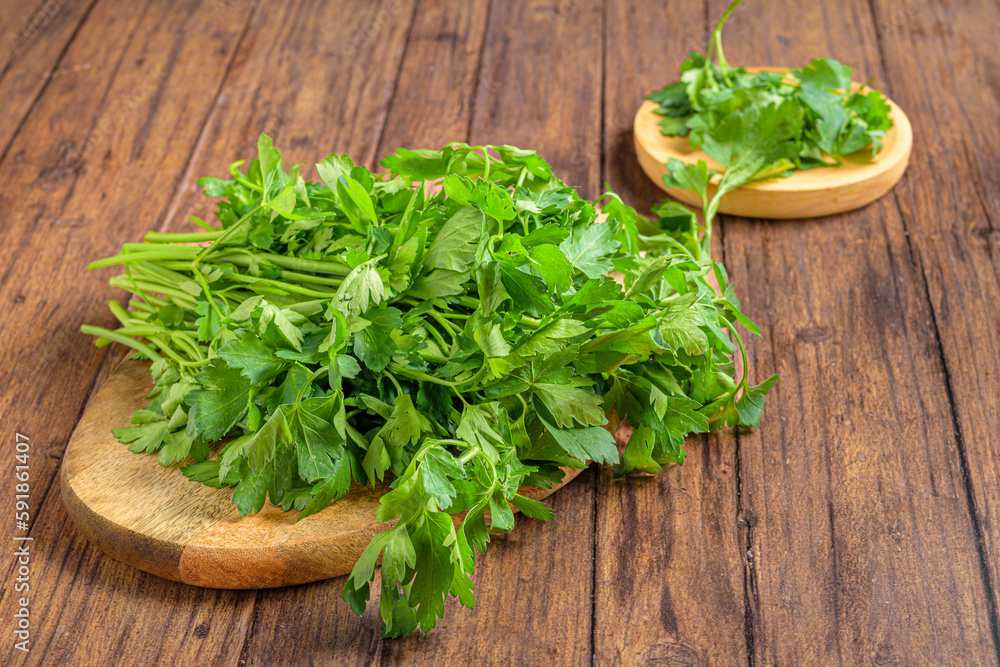 Closeup shot of fresh parsley (Petroselinum crispum) on the wooden trays Closeup shot of fresh parsley (Petroselinum crispum) on the wooden trays