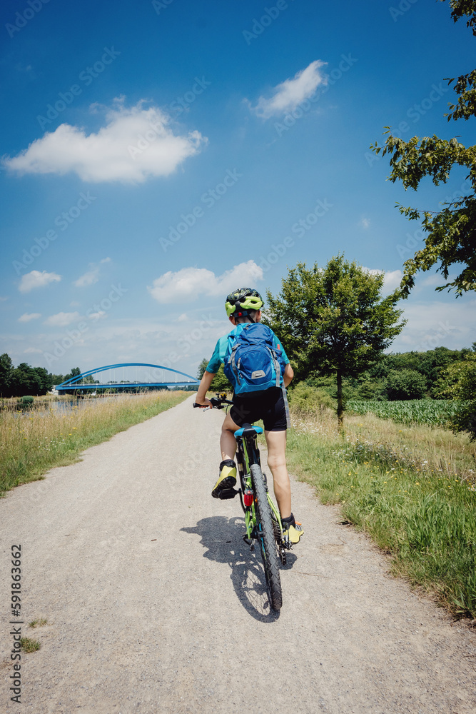 Junge auf einer Fahrradtour entlang des Dortmund-Ems Kanals bei Münster in den Sommerferien, Deutschland