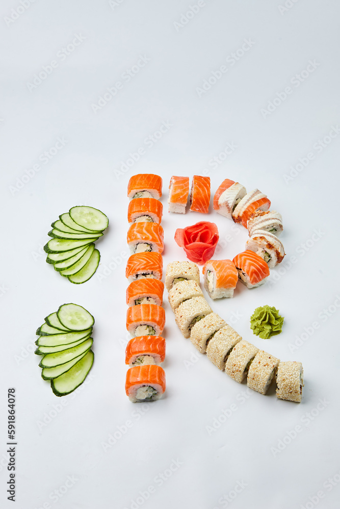 Naklejka premium Traditional delicious fresh sushi set Philadelphia roll with salmon, smoked eel and cucumber isolated on white background. Sushi menu. Japanese asian food
