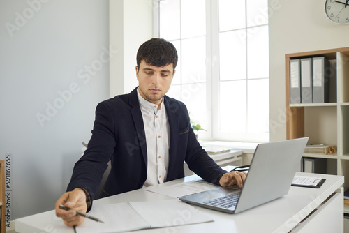 Foto Business man on online meeting with clients writing making notes during conversation in laptop sitting at desk in office