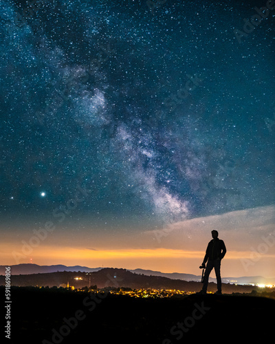 Vertical shot of a Caucasian man looking at the landscape in Germany at night