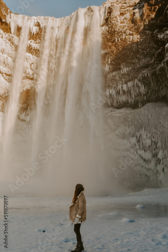 Fototapeta Naklejka Na Ścianę i Meble -  Young female traveller exploring waterfall in Iceland