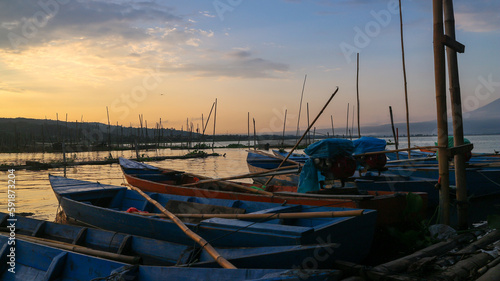 Fishing boats on the edge of Rawa Pening lake at sunrise, sunset. Rawa Pening is a lake located in three districts namely Tuntang, Ambarawa, Banyubiru Semarang. photo