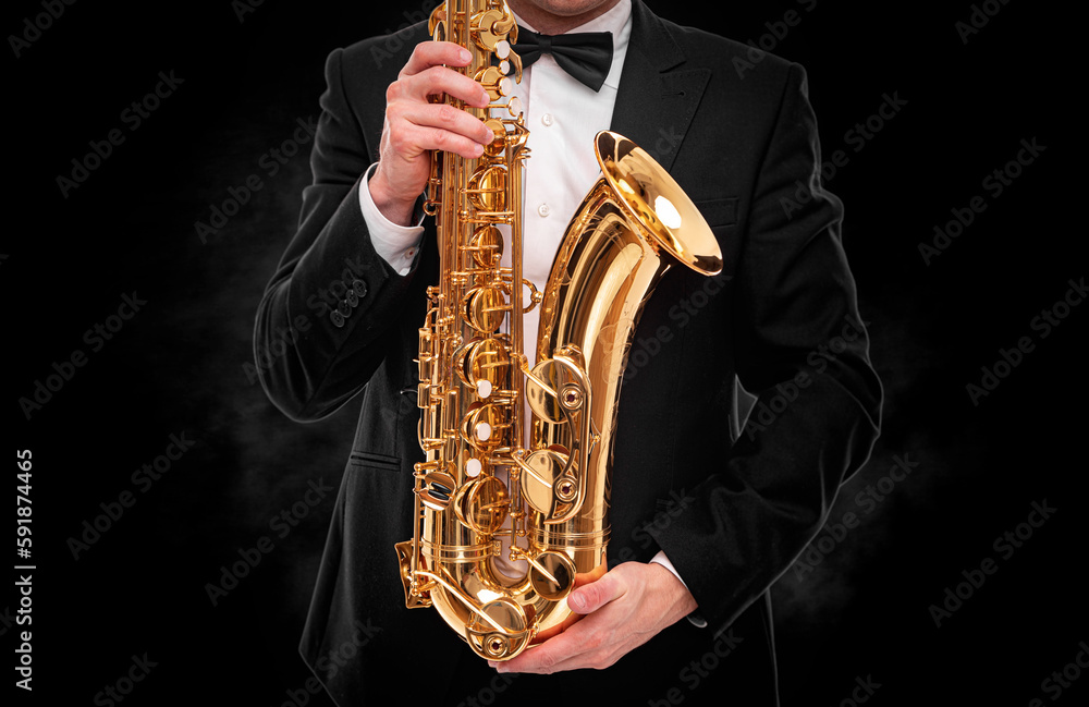 Naklejka premium Saxophonist on a black background.