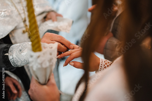 Engagement. The process of exchanging wedding rings. Tradition at the wedding ceremony in a church. Wedding day. Hands with wedding rings. Close up.