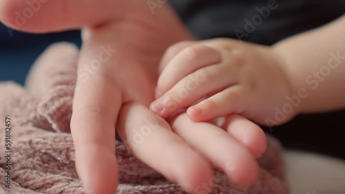 mother holds the hand of a newborn. children hand. hospital takes care of happy family medicine concept. newborn baby holding mom hand close-up. mom takes care baby in dream the hospital photo