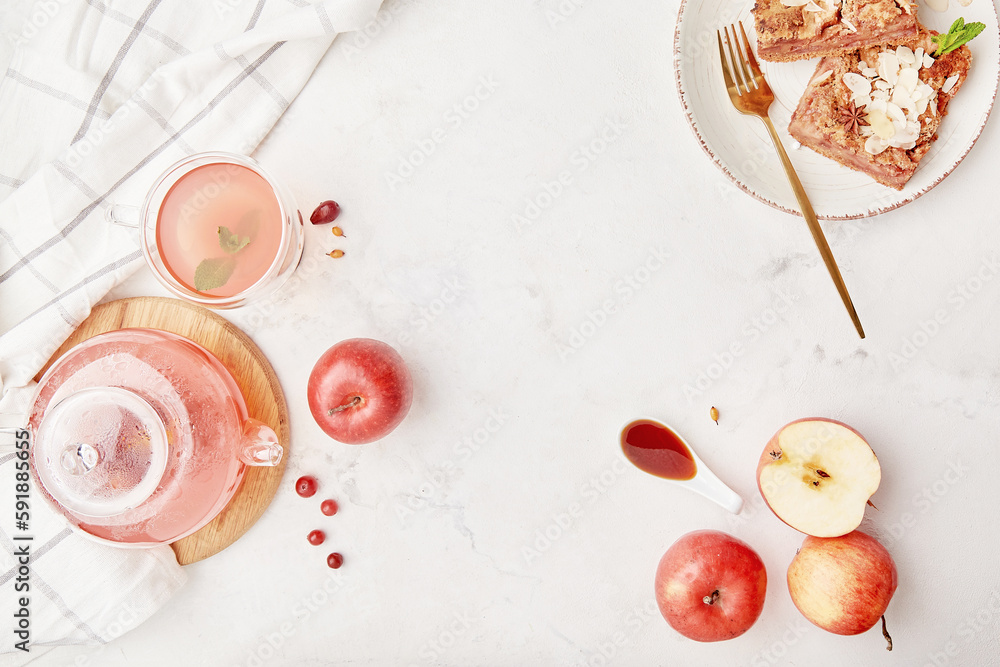 Glass teapot with natural cranberry tea and slices of homemade apple pie with almond flakes and apples. Copy space Glass teapot with natural cranberry tea and slices of homemade apple pie with almond flakes and apples. Copy space