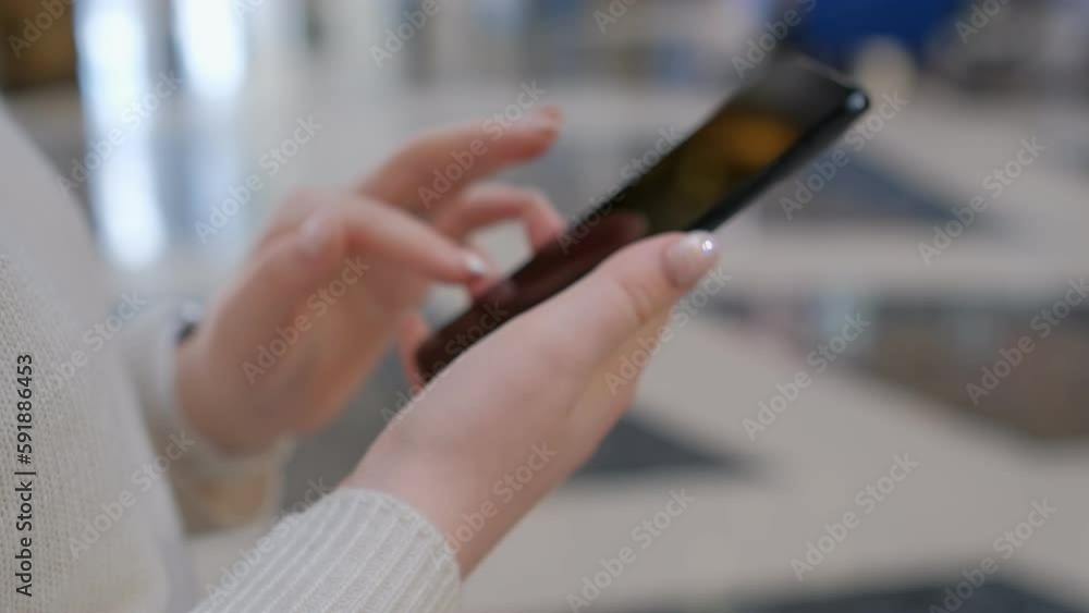 Hands of young woman using smartphone in the street near shopping mall. Communication, online shopping, chat, social networking concept. Close up