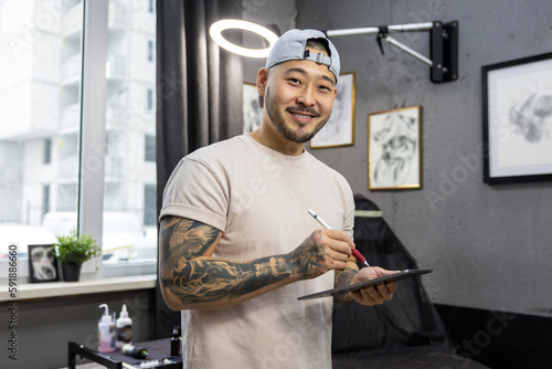 Tableau sur toile Tattoo master working on new ideas and looking excited
