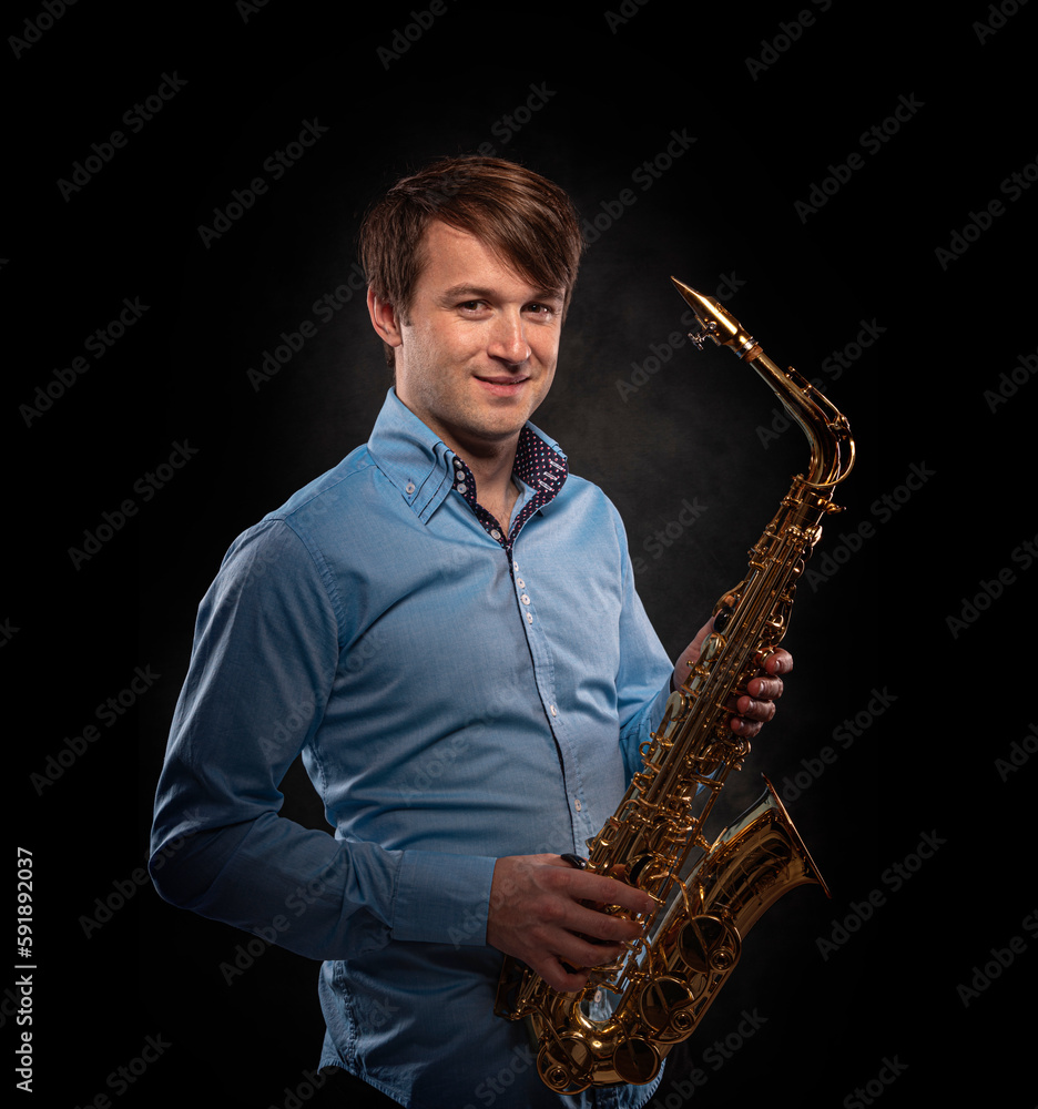 Fototapeta premium Saxophonist on a black background close-up.