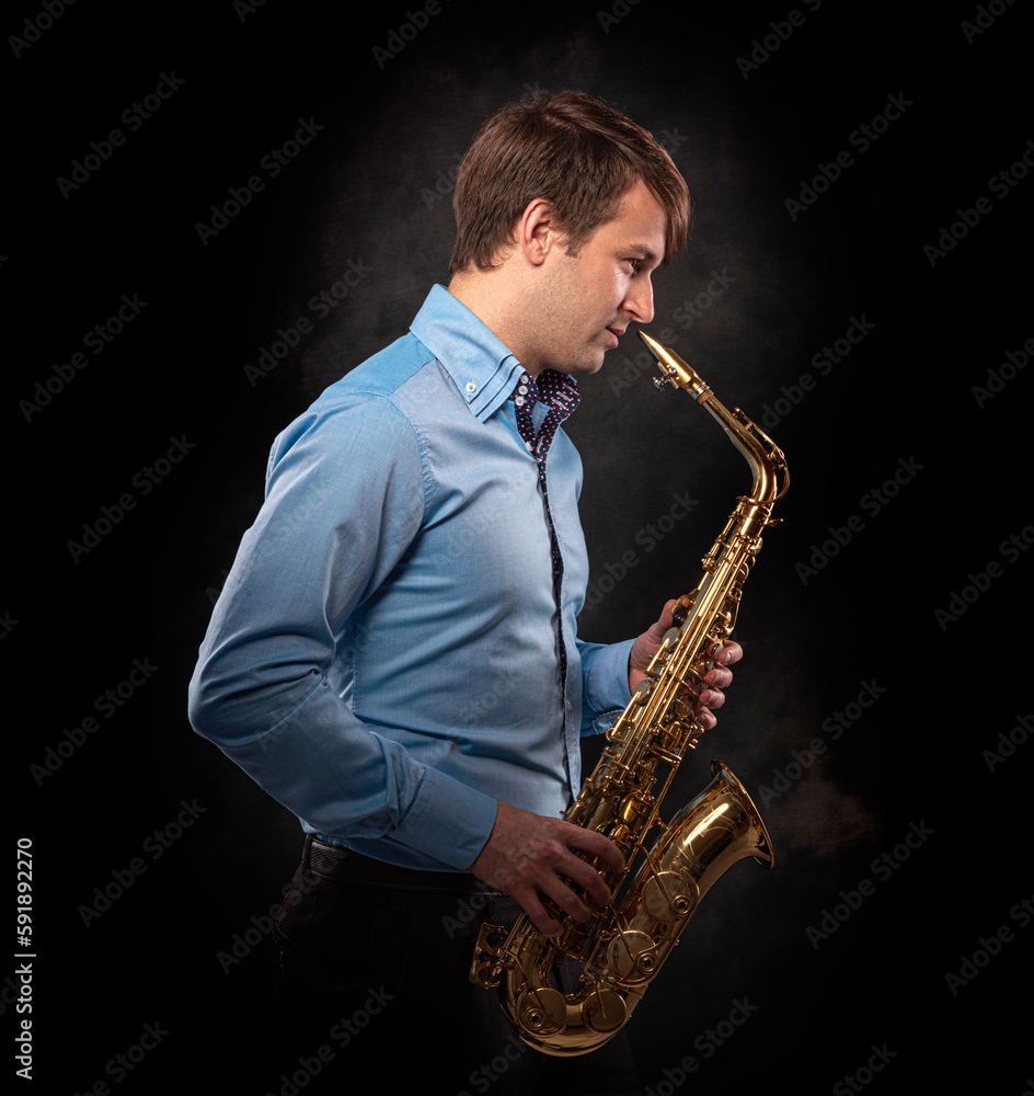 Fototapeta premium Saxophonist on a black background close-up.