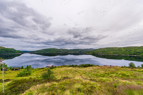 Norway Landscape with Lake and Reflection. Cloudy Blue Sky.