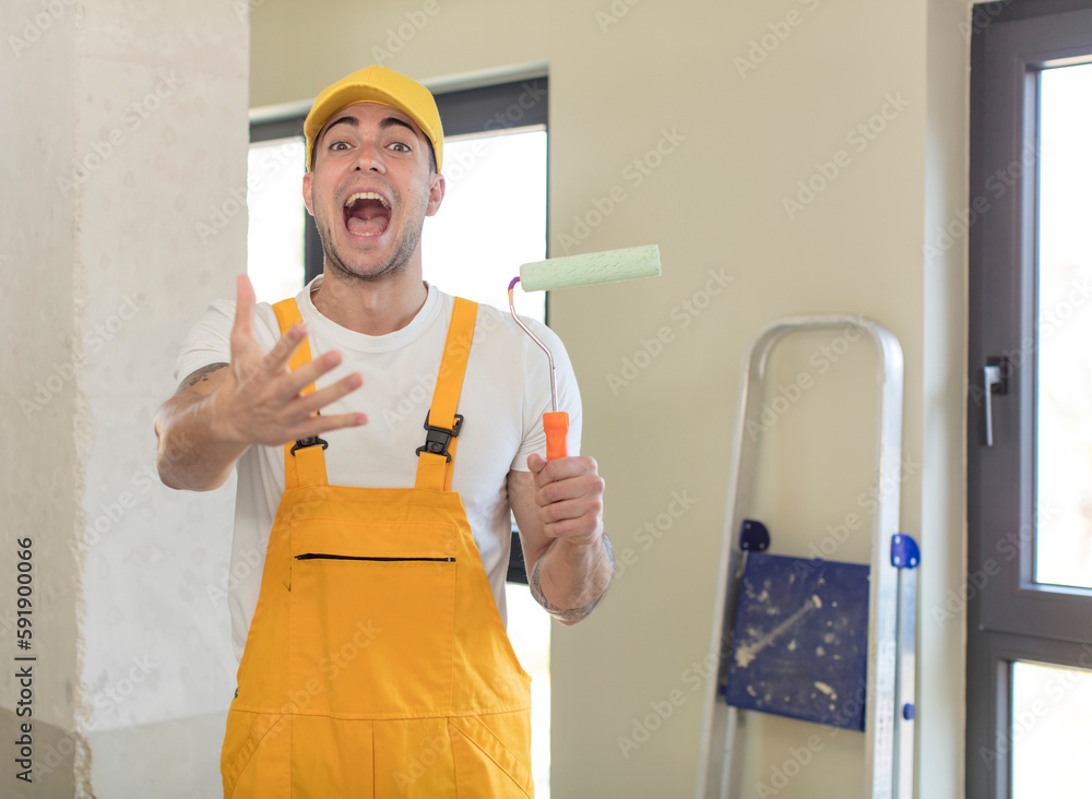 young handsome man smiling happily and offering or showing a concept. painting home concept young handsome man smiling happily and offering or showing a concept. painting home concept