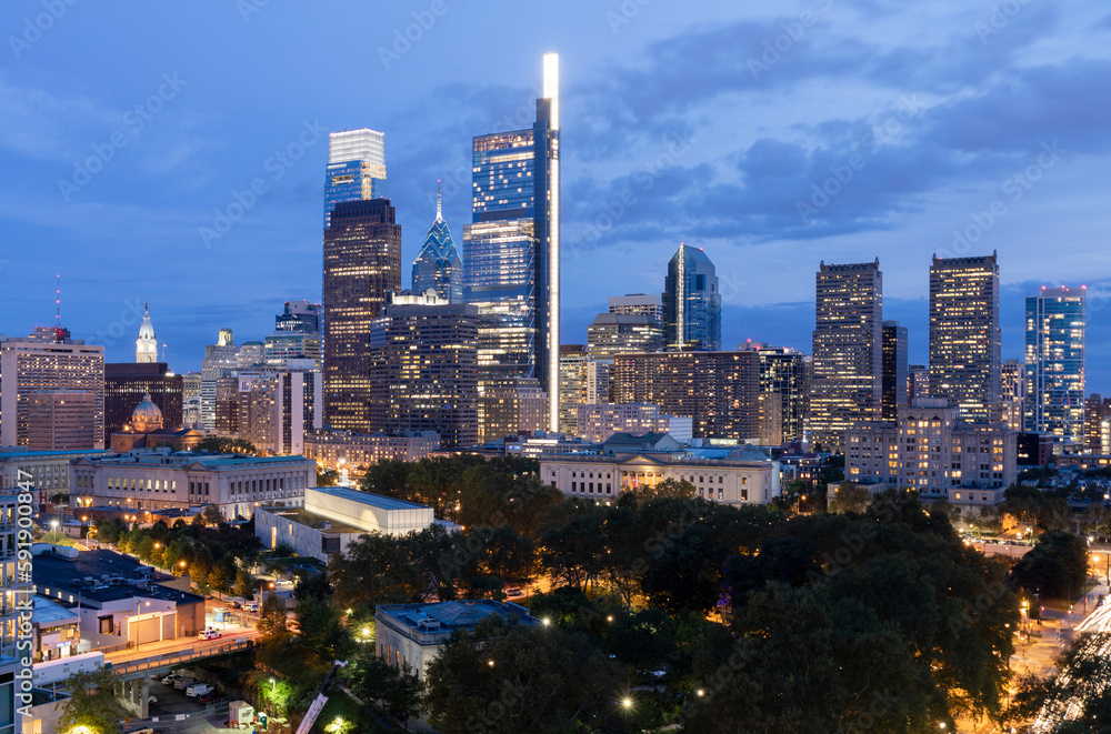 Fototapeta premium Philadelphia City Center and Business District Skyscrapers. Pennsylvania. Cloudy Blue Sky. Philadelphia Downtown. Evening Lights. Night Time.