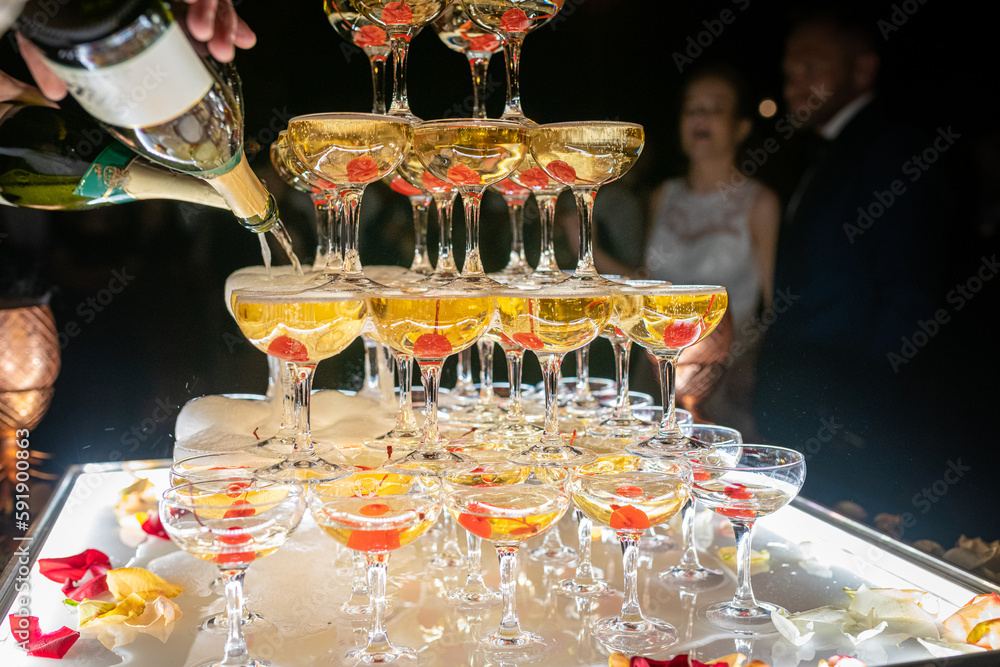 Champagne glasses standing in a tower at the wedding party. Champagne glass pyramid. Pyramid of glasses of wine, champagne, tower of champagne. Wedding party.