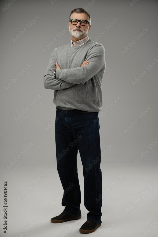 Full length of happy casual mature man smiling, senior age man with gray hair, Isolated on gray background Full length of happy casual mature man smiling, senior age man with gray hair, Isolated on gray background