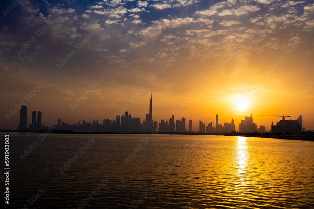 Dubai skyline during sunset. Dubai's skyline cast long shadows, creating a stunning silhouette against the evening sky.