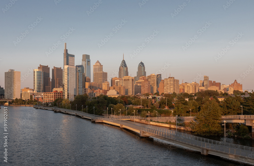 Philadelphia Downtown skyline with the Schuylkill river. Beautiful Sunset Light. Schuylkill River Trail in Background. City skyline glows under the beautiful sunset light