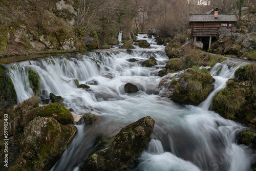 Mountain river with mossy rocks and wooden watermills in long exposure, river Krupa in Krupa na Vrbasu photo