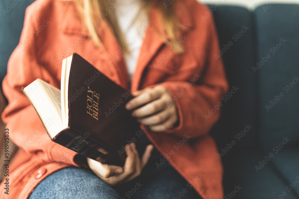 Obraz premium A woman is holding a Bible and praying. Studying the Holy Scriptures. Spiritual growth. Faith and spirituality. Bible study and prayer. Oration.