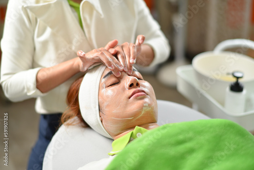 The woman has a facial treatment , face massage
