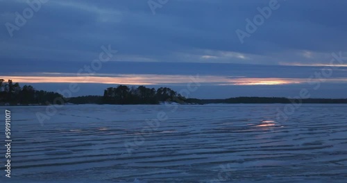 Sunset at seashore with sea ice and cloudy weather in winter, Lauttasaari, Helsinki, Finland. photo