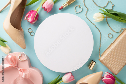 Mother's Day surprise concept. Chic and stylish top view of high-heels, handbag, gift box, tulip flowers, lipstick, makeup brushes, and earrings on a pastel blue background with blank circle
