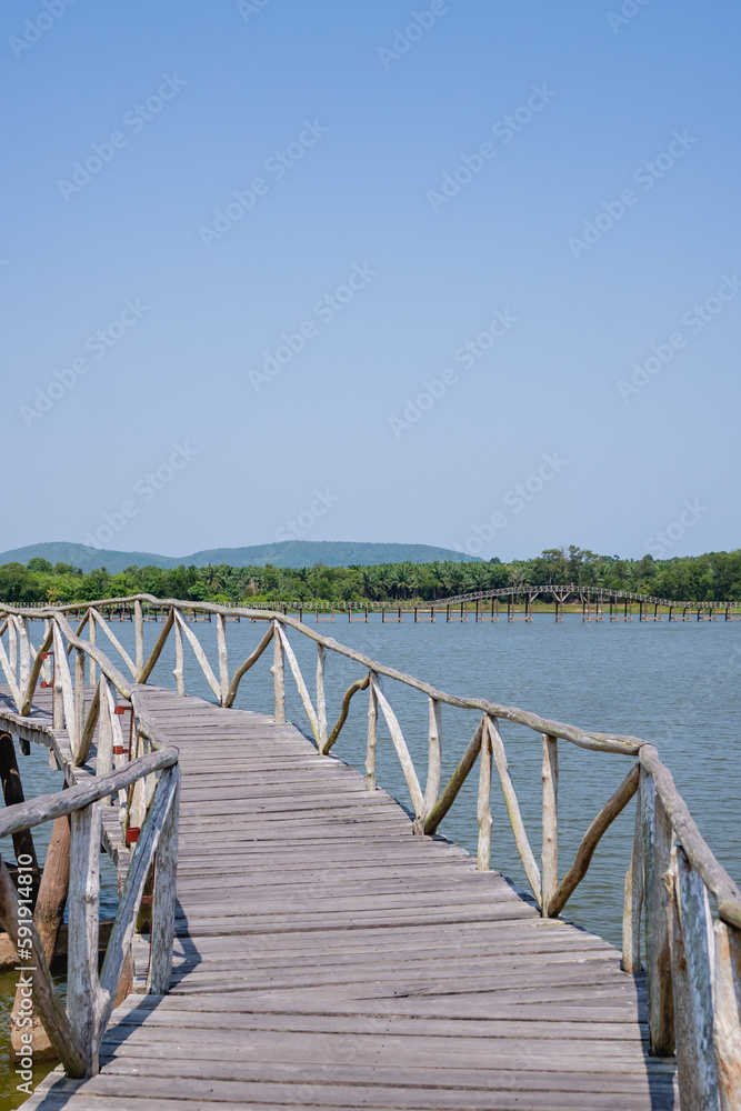 A long wooden bridge extending into the reservoir