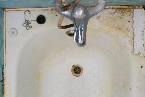 Very dirty bathroom. Very dirty bath, water drain, sewerage, water faucet mixer tap, sewage, overflow shower. Dirt and rust in the bathtub room. Cleaning disinfection required. Unsanitary, microbes
