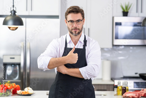 Man chef cooker baker. Millennial male chef in chefs uniform. Chef man cooking on kitchen. Chef cook in hat and apron.