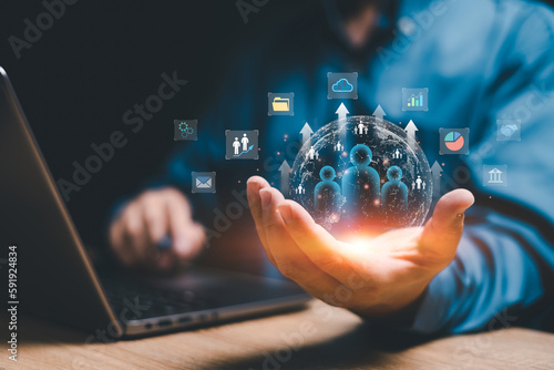 Customer network relationship management concept on virtual screens, Businessman use laptops and hold global structure customer network in hand, Data management and business work development photo