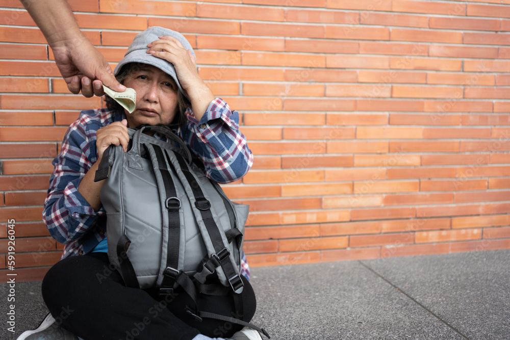 Poor tired stressed depressed elderly Asian woman homeless sitting on the street in the shadow of the building and begging for help and money, Elderly Asian woman abandoned concept Poor tired stressed depressed elderly Asian woman homeless sitting on the street in the shadow of the building and begging for help and money, Elderly Asian woman abandoned concept