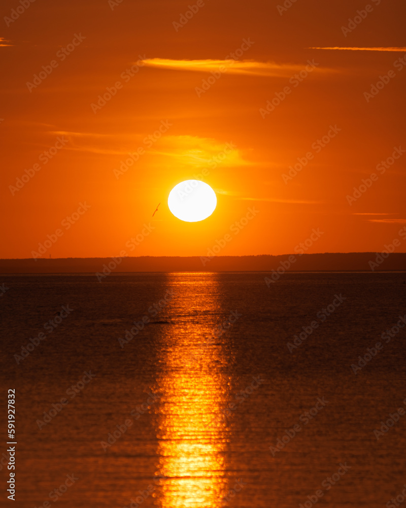 sunset on background of ocean or sea, beautiful orange color in nature. freedom and rest, observation and contemplation of view of the sun and sky. reflections of light play of waves