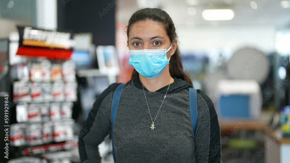 Portrait of woman wearing surgical face mask indoors. Female person using protective accessory during pandemic