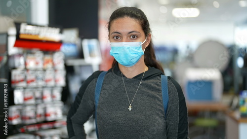 Portrait of woman wearing surgical face mask indoors. Female person using protective accessory during pandemic