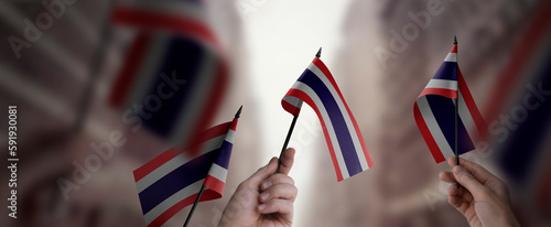 Fototapeta Naklejka Na Ścianę i Meble -  A group of people holding small flags of the Thailand in their hands