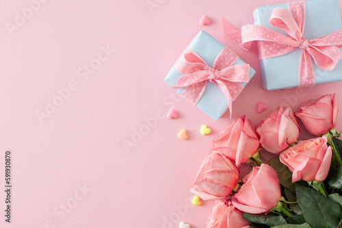 Mother Day gift concept. Top view photo of bouquet of pink roses present boxes with bows and small hearts baubles on isolated pastel pink background with copyspace