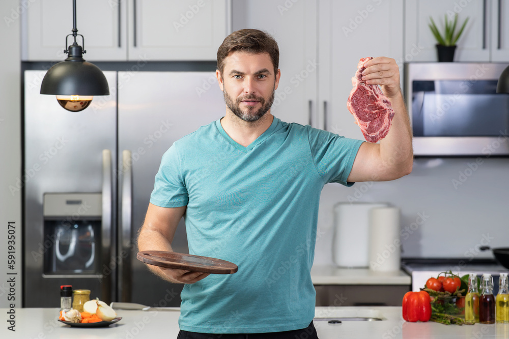 Man chef cooker hold meat beef. Male chef with raw meat beef fillet. Fork veal filet, roasting steak. Raw beef steak. Chef man cooking raw meat beef on kitchen. Man chef cooker hold meat beef. Male chef with raw meat beef fillet. Fork veal filet, roasting steak. Raw beef steak. Chef man cooking raw meat beef on kitchen.
