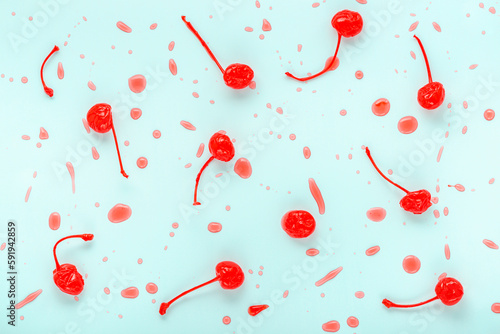 Photos maraschino cherries with drops on blue background, trendy flat lay, minimal styl