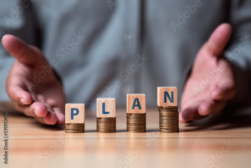 Investment and saving concept, businessman 's hand with word GOAL on money coin stacking. deposit and money plan concept.